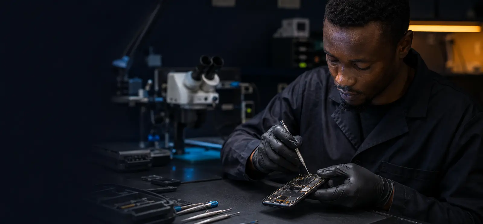 Mobile-device technician working at a professional electronics repair bench